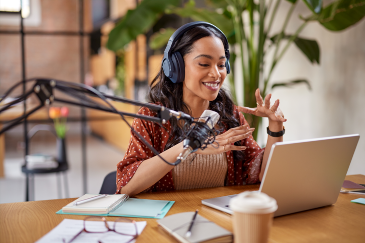 Smiling young latin woman recording podcast about how to promote a podcast on social media